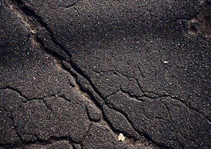 Closeup of cracked asphalt road