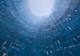 A low angle futuristic shot of a blue cooling tower showing brick structure