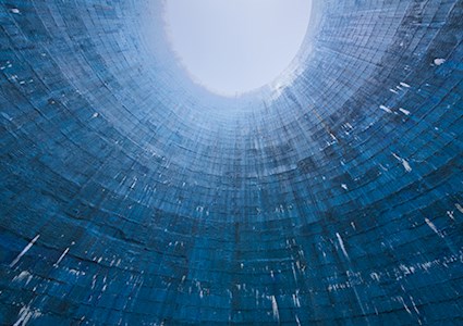 A low angle futuristic shot of a blue cooling tower showing brick structure