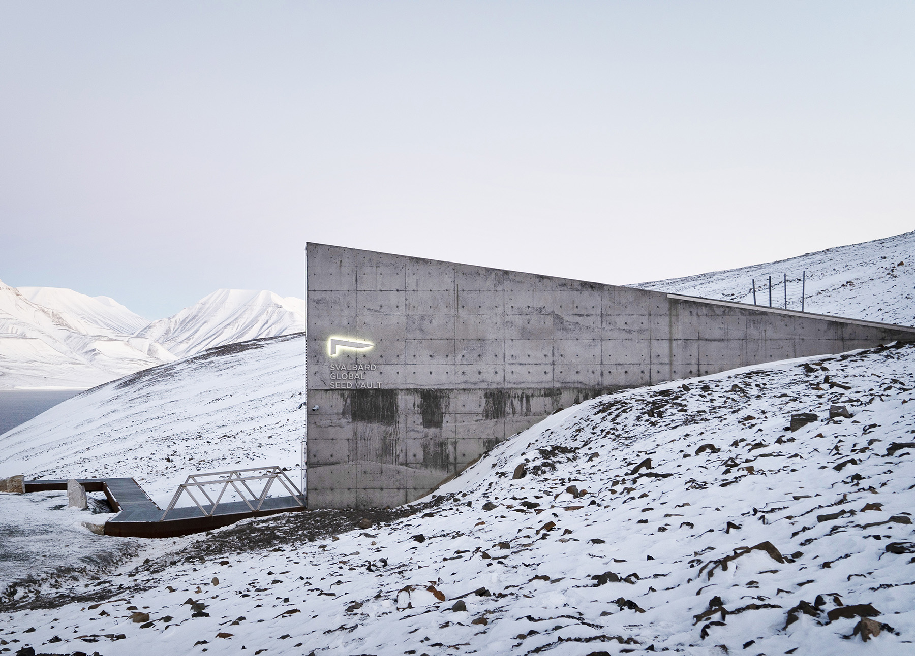 The angled form of the concrete seed vault emerges from the frozen ground.